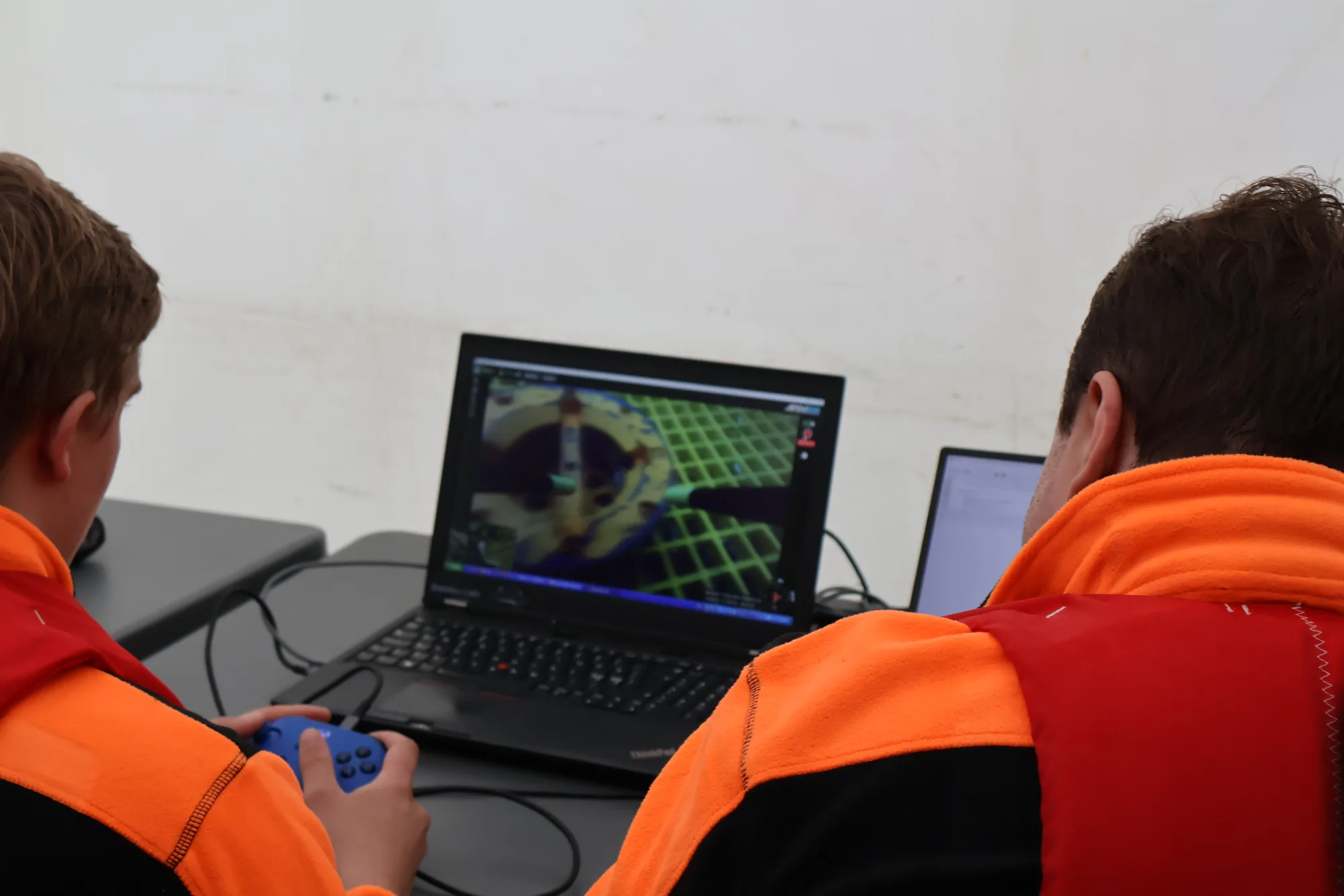 Two students operating an ROV from laptops